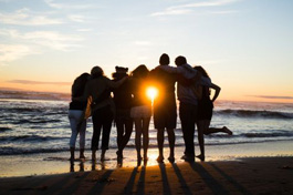students on beach at sunset
